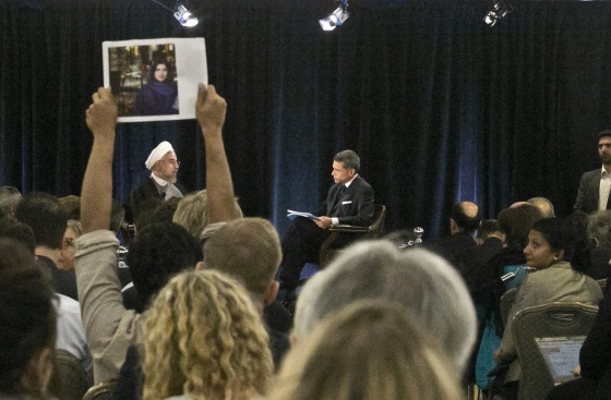 A protester holds up a picture of Ghoncheh Ghavami as Iran's President Dr. Hassan Rouhani, left, speaks with moderator Fareed Zakaria at New America, a public policy institute and think tank in New York on Wednesday, Sept. 24, 2014. Ghavami, a 25-year-old British-Iranian citizen, was among 50 women arrested in June for trying to watch a volleyball match from inside a stadium. (AP Photo/Bebeto Matthews)