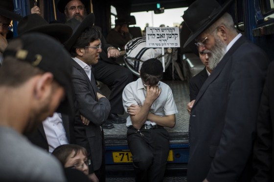 Image: Mourners gather for the triple funeral of Rabbi Kalman Levine, Avraham Goldberg and Arieh Kupinsky