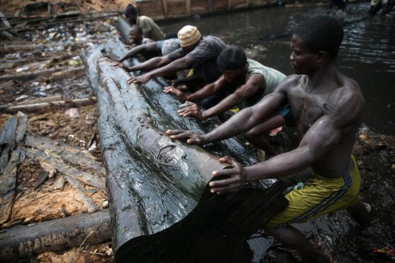Image: Men push a log out of the water
