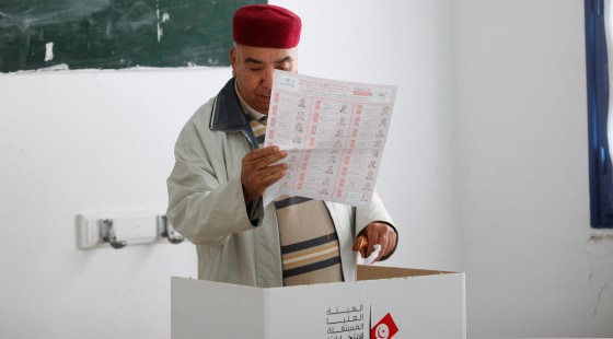 A man looks at his ballot while voting at a polling station during Tunisia's presidential election in Tunis on Nov. 23, 2014. Tunisians went to the polls on Sunday to vote for their first directly elected president since the 2011 revolution that ended the regime of Zine el-Abidine Ben Ali. REUTERS/Zoubeir Souissi