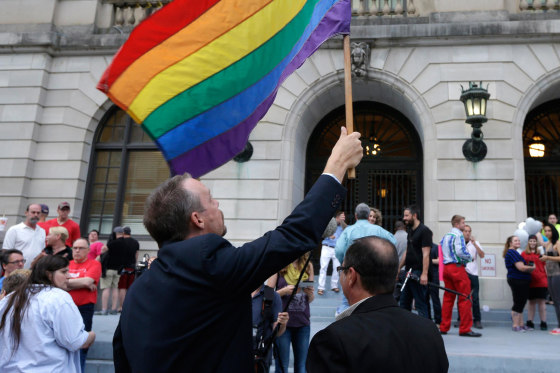 Image: Same-sex marriage supporters hold a flag at the Pulaski County Courthouse in Little Rock, Ark.
