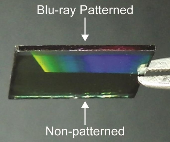 A surface partly covered by the Blu-ray pattern that shows how it diffuses light (as shown by the rainbow gradient).