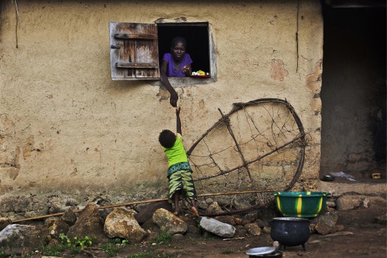A child grabs food from a woman in the Guinean village of Meliandou, some 400 miles south-east of Conakry, Guinea, believed to be Ebola's ground zero, on Nov. 23. The official theory is that somehow the virus was transmitted from fruit bats to humans and spread through the region plagued with bad roads, dense population, and a problematic health care system along a porous borders that people used to cross regularly –before the outbreak—whether to join family or engage in trade.