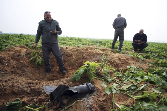Israeli security forces stand next to the remains of a rocket that was fired from the Gaza Strip towards Israel on Friday, on the Israeli side of the border