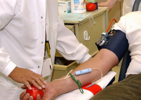 Image: A Red Cross worker as she prepares to take blood from an unidentified male donor in California