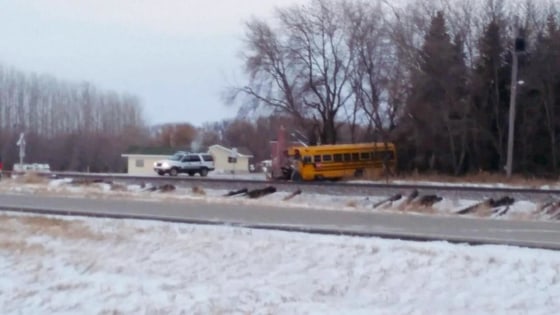Image: A school bus sits at the scene of a collision with a BNSF train just south of County Road 4 east of Larimore, N.D.