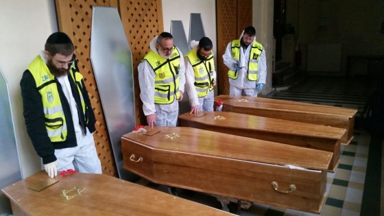 Image: Members of the Zaka emergency response team pray beside the coffins of four victims of an attack at a kosher supermarket on Friday, before their transport from Paris to Israel for burial, in Paris