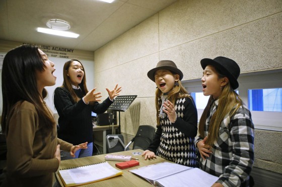 Kim Si-yoon (2nd R) and Yoo Ga-eul (R) take part in a singing lesson at DEF Dance Skool in Seoul November 15, 2014. 