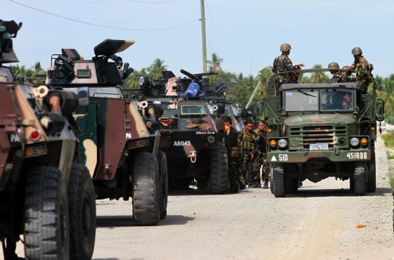 Image: Military personnel ride on a truck past APCs in the town of Mamasapano in the Philippines on Monday