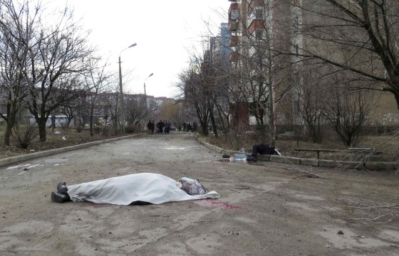 Image: The covered bodies of victims are seen outside a building neighbouring a hospital in Donetsk