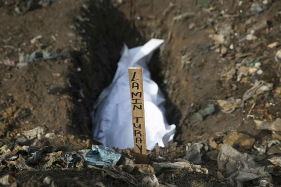 Image: The body of a suspected Ebola victim awaits burial in a grave at a cemetery in Freetown