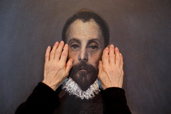 Image: A blind person feels with her hands a copy of 'The gentleman with his hand on his chest'