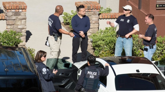 Chao Chen, center, surrounded by federal agents after his apartment in Mission Viejo, California, was raided Tuesday morning.