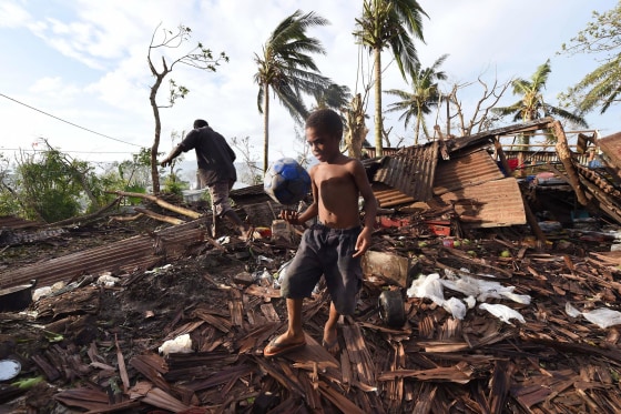 Image: Boy carries ball through ruins