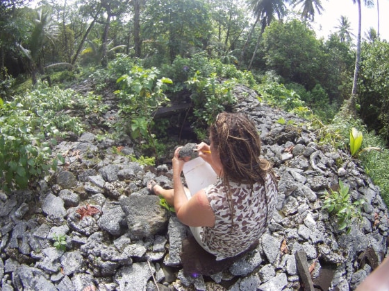 Zoe Richards, a researcher from the Western Australian Museum, inspects one of the corals used to build the sacred twin tomb known as Bat.