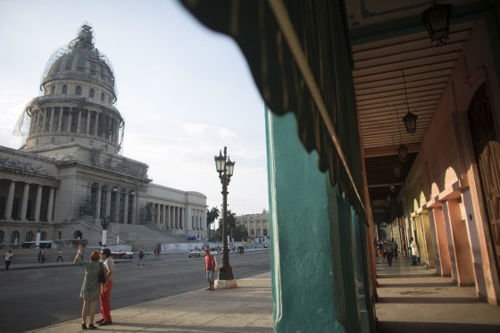 Image: Tourists stand near the Capitol in Havana
