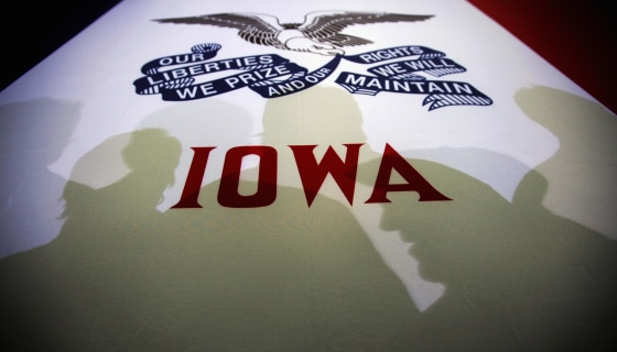 Image: Potential caucus voters cast shadows on an Iowa state flag at a campaign rally for Republican presidential candidate and former Massachusetts Governor Mitt Romney in Clive