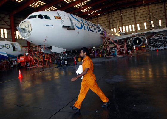 Image:An engineer walks past a Sri Lankan Airlines jet on Feb. 10