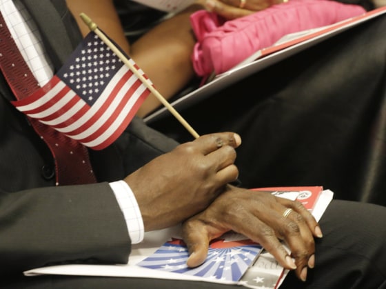 A new U.S. citizen holds an American flag during a naturalization ceremony in July. An Arizona law will require graduating high school seniors to pass the same civics test given to candidates for U.S. citizenship. 
