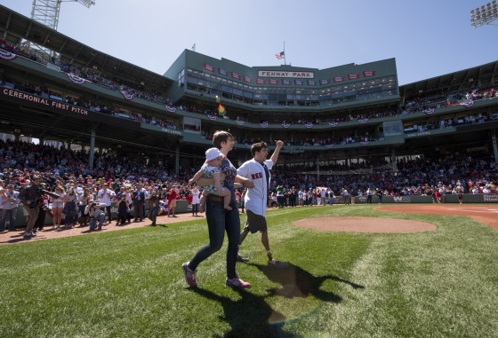 Boston Marathon bombing victim Jeff Bauman heads to the mound with his wife Erin Hurley to throw out a ceremonial first pitch before a game between the Boston Red Sox and the Washington Nationals on April 15, 2015 at Fenway Park in Boston, Massachusetts. 