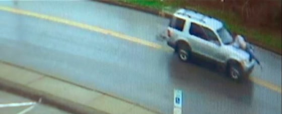 Surveillance video shows a man hanging onto the hood of a car in Springdale, Pennsylvania. 