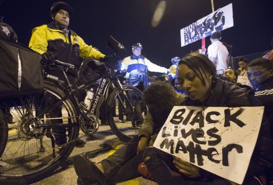 Image: Protesters sit in during a moment of silence in front of a line of police officers, in solidarity with protests over the Baltimore death of Freddie Gray, in Chicago