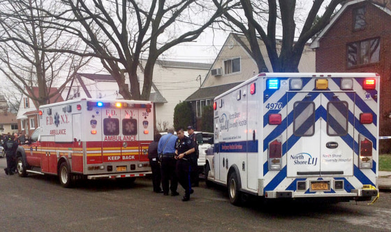 Image: Emergency personel gather near a home where police say four people were found dead in an apparent carbon monoxide poisoning