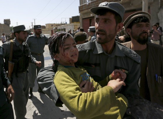 Image: A policeman carries an injured boy from site of an attack in Kabul, Afghanistan