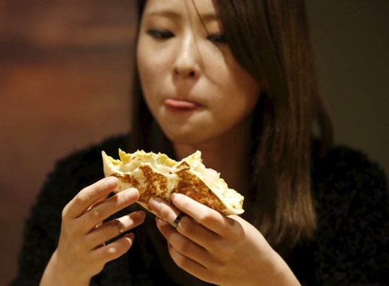 Image: A woman eats a taco at Taco Bell