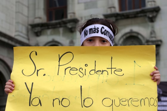 Image: A protester holds a sign during a demonstration demanding the resignation of Guatemalan President Otto Perez Molina in Guatemala City