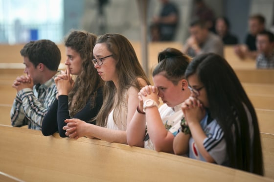 Image: Some young attendees sit in prayer during a special Mass for the victims of the Berkeley balcony collapse in Oakland, California