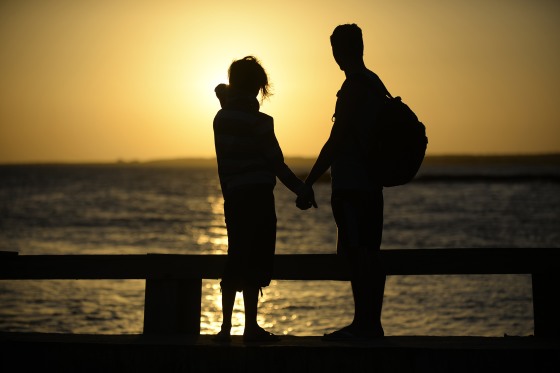 Image: A couple hold hands near the shore of El Yaque Beach