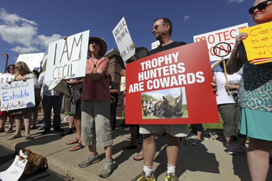 Protesters rally outside the River Bluff Dental clinic against the killing a famous lion in Zimbabwe, in Bloomington, Minnesota July 29, 2015. Wildlife officials on Tuesday accused American hunter Walter Palmer of killing Cecil, one of the oldest and most famous lions in Zimbabwe, without a permit after paying $50,000 to two people who lured the beast to its death. As of Tuesday, Palmer had temporarily closed his office, River Bluff Dental, in Bloomington, Minnesota, amid wishes for his death and widespread criticism of his hunting on social media and under business reviews on Google and Yelp. REUTERS/Eric Miller - RTX1MC0W