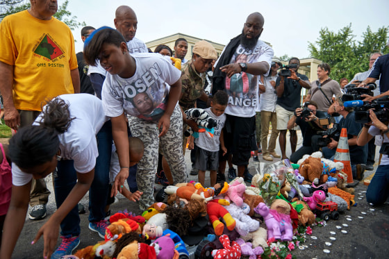 Michael Brown Sr., father of slain 18 year-old Michael Brown Jr. points to stuffed animals along with Brown family members prior to a march of solidarity on August 8 in Ferguson, Missouri. 