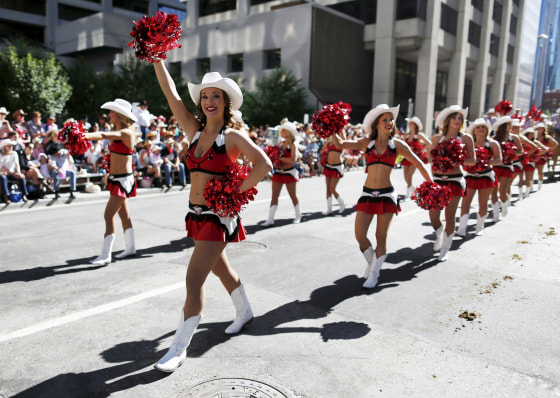 Image: Members of the Calgary Stampeders cheerleading squad march during the Calgary Stampede parade in Calgary