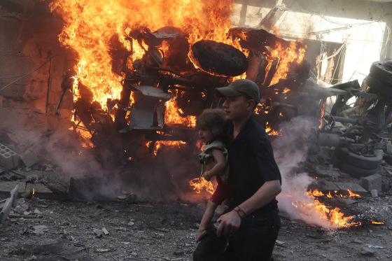 Image: A girl is evacuated from a site, which was hit by what activists said were airstrikes by forces loyal to Syria's President Bashar al-Assad, in the Douma neighborhood of Damascus, Syria