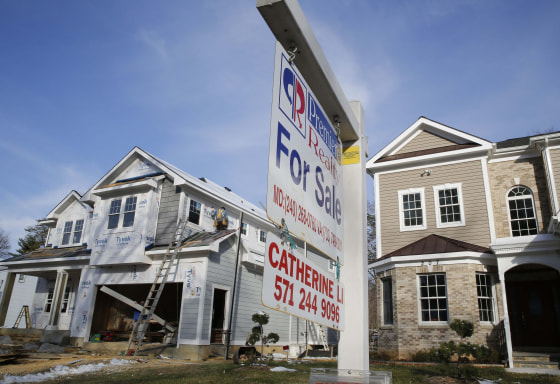 Image: File of new home is being built next to a home with a for sale sign on a street in Vienna