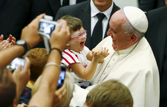 Image: Pope Francis laughs with a baby during a special audience with parish cells for the evangelization in Paul VI hall at the Vatican