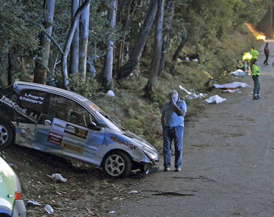 Image: Emergency workers survey the area where six people were killed by an out-of-control car at a rally in northwestern Spain