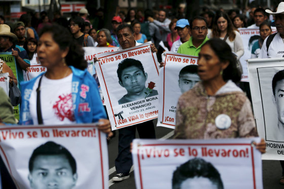 Image: Relatives carry photos of some of the 43 missing students of the Ayotzinapa teachers' training college during a protest to mark the eleven-month anniversary of their disappearance in Mexico City
