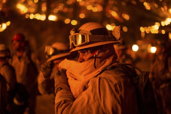 Image: Firefighter covers his face while battling the Butte fire near San Andreas