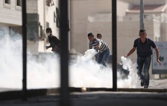 Image: Palestinians prepare to return tear gas canisters fired by Israeli troops during clashes at a protest against an Israeli police raid on Jerusalem's al-Aqsa mosque, in the occupied West Bank town of Al-Ram, near Jerusalem