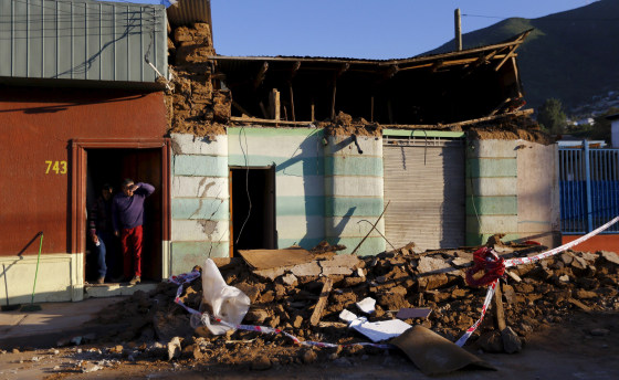 Image: A resident looks on near debris of a damaged house after an earthquake hit areas of central Chile, in Illapel.