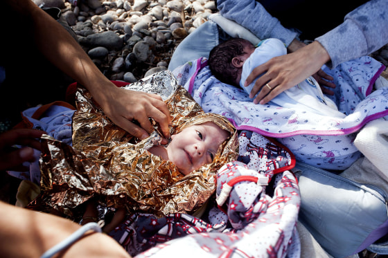 Image: Eight-month old twins from Syria lie on Eftalou beach, west of the port of Mytilene, on the Greek island of Lesbos after their parents crossed the Aegean sea from Turkey