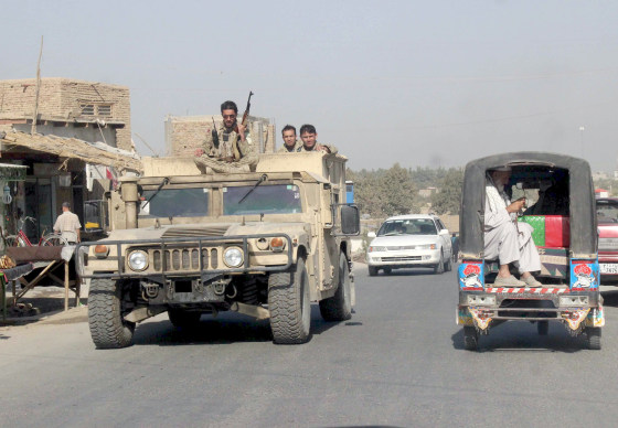 Image: Afghan security forces travel on an armored vehicle in Kunduz province