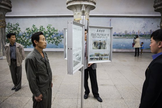 Image: People read newspapers displayed inside a subway station visited by foreign reporters during a government organised tour in Pyongyang