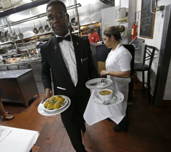 Image: Waiter brings dishes to dining room