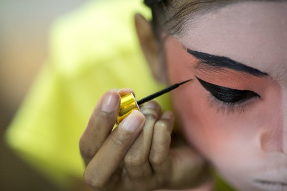 Image: A member of a Chinese opera troupe applies make-up before performing at a shrine during the annual vegetarian festival in Bangkok