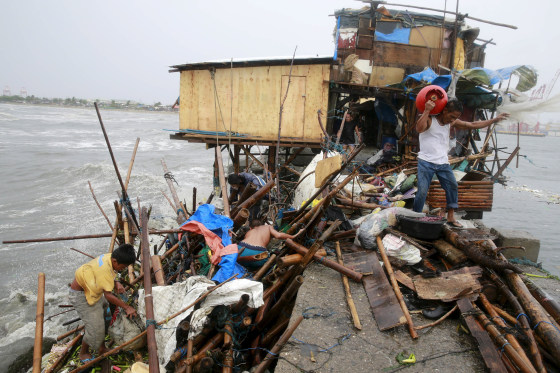 Image: A Taroyo family living along the coast of Manila Bay searches for salvageable items after their house was damaged by strong winds brought by typhoon Koppu