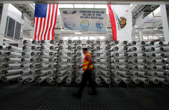 Image: Jason Dadakis walks past part of the water filtration system